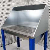 Steel downdraft table on blue legs with white background